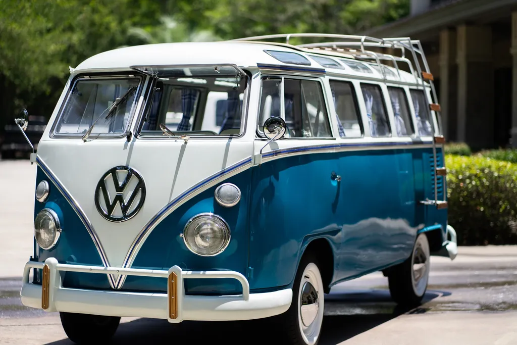 A restored blue and white Volkswagen bus, finished and parked outside.
